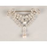 Diamond bar brooch, diamond set bows to either end with three suspended rows of diamond florets. Top