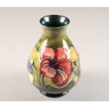 Moorcroft pottery vase, green ground decorated with hibiscus pattern, signed in blue height 21.5cm