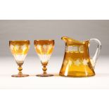 Set of six Bohemian amber flashed glasses and matching amber jug, engraved with vines and grapes,