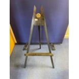 Ebonised easel with brass roundel. 106cms high.