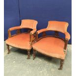Pair of Edwardian drawing room tub armchairs upholstered in later pink velour, raised on turned
