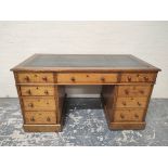 Oak pedestal desk with turned knobs, tooled leather top and long drawer, flanked by four short