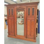 late Victorian mahogany triple wardrobe with large central mirror flanked by carved floral panel