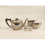 Silver three-piece tea set, part fluted, by Deakins, Birmingham, 1911, also a toast rack, 974g.  (4)