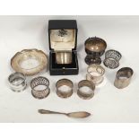 Silver napkin ring, cased; eight others; a butter dish with knife and a cup, 294g.  (11).