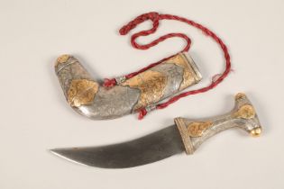 A middle Eastern Omani white metal mounted Jambiya dagger, with gilt enrichments and engraved