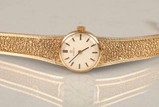 Ladies 9ct yellow gold Omega wrist watch, champagne dial with hour marker batons on a textured 9ct