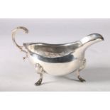 Silver sauceboat with scrolled handle and shell knees on cabriole supports, hallmarked Toye, Kenning