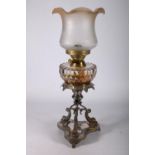 Duplex oil lamp circa early 20th century with later glass shade above glass reservoir and repousse