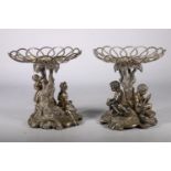 Cast metal plate stands likely from epergne set, one with boys fishing the other with children