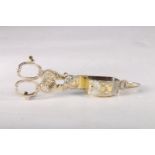 George III gilt silver candle snuffer with shell decoration and two sets of family arms, hallmarked