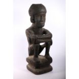 African or Yene carved figure of seated man with recess to top of head, 50cm.