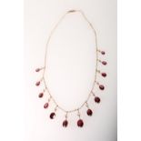 Yellow metal stone set necklace with thirteen oval shaped fine garnets and white sapphires, 16cm,