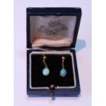 Pair of opal drop earrings, each oval opal dependant from a bead.