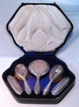 Silver five-piece toilet set with moulded edges, cased.