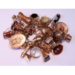 Gold bracelet with a variety of charms, some glass, hardstones and other materials, mostly 9ct gold,