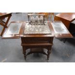 Carved oak drinks cabinet by Maple & Co., with two divisions to the top opening to reveal a rise and