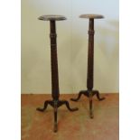 Pair of mahogany torchères, c. early 20th century, each with a saucer top above turned reeded column