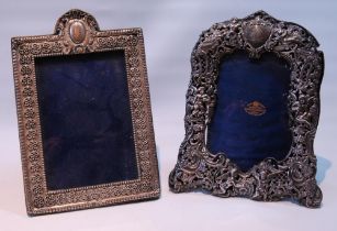 Silver photograph frame pierced with putti and scrolls, by W Comyns, 1895, 22cm x 17cm, and another.