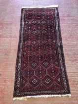 Baluch runner with hooked medallion motif to field with scrolling borders, 200 x 97cm.