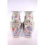 Pair of Chinese Canton famille rose vases, with vignettes of figures and relief animal decoration,
