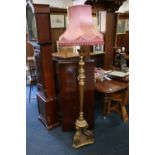 A carved giltwood standard lamp with pink shade, 162cm to top of brass fitting. #83