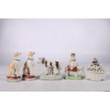 A group of five Staffordshire porcelain figures comprising two dogs, a pair of dogs, a girl on