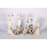 A porcelain figure of a boy with a dog, 22cm tall, a pair of white glazed figural candlesticks and