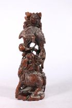 Chinese rootwood carving modelled as a kylin and peacock fighting, 31cm high.