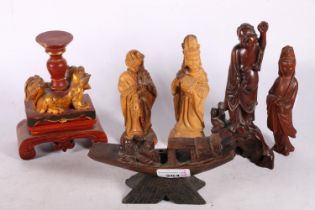 Carved wooden Fu dog on footed stand, painted red and gold, 11.5cm high, a carved wooden boat on