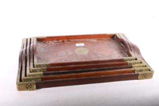 Five nested brass bound Chinese trays, the largest 53cm long. #306