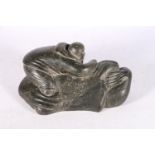 Canadian Inuit serpentine or soapstone carving of a hunter with seal, 29cm long.