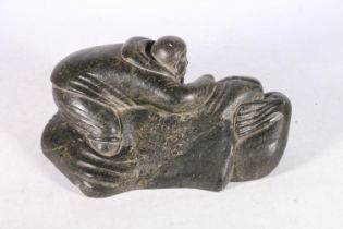 Canadian Inuit serpentine or soapstone carving of a hunter with seal, 29cm long.