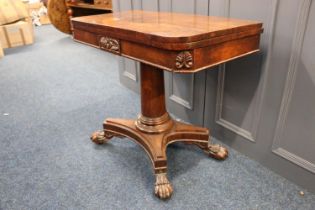 A Georgian rosewood card table, with turn-over top, carving to apron, raised on turned column
