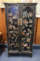 An early 20th century Chinese lacquered wardrobe style cupboard painted with figures and flowers,