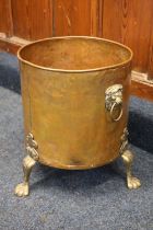 Large copper and brass coal bin with lion mask handles raised on paw feet, 45cm tall.