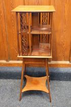 An Edwardian mahogany and satinwood banded revolving bookcase, raised on tiered stand with splayed