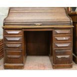 Cutler oak roll-top desk with tambour front and fitted interior, 125cm wide.