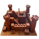 Wooden castle building set within mahogany blanket box.