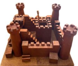 Wooden castle building set within mahogany blanket box.