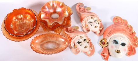Eight pieces of Carnival glass and a set of three graduated ceramic wall masks.