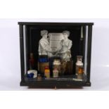 Collection of medical items, arranged within glass display case, case measures 38cm high.