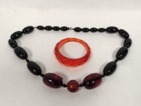 Amber bead necklace of graduated oval beads and a faceted bangle.