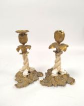 Pair of 19th century brass candlesticks with relief tulip decoration to the sconce, white ceramic