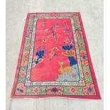 Chinese red ground rug, a deer in the corner below a blossom tree with birds, decorative cream guard