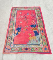 Chinese red ground rug, a deer in the corner below a blossom tree with birds, decorative cream guard