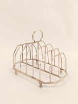 Silver toast rack for six with plain wires and angled handle and base on bun feet by S Hennell, 1805