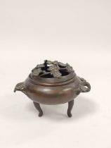 Antique Chinese bronze koro with foliate pierced cover and handles, on tripod feet, with stand, 13cm