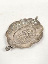 Continental silver oval lobed dish with silver handles and embossed scene of a boy on a dolphin.