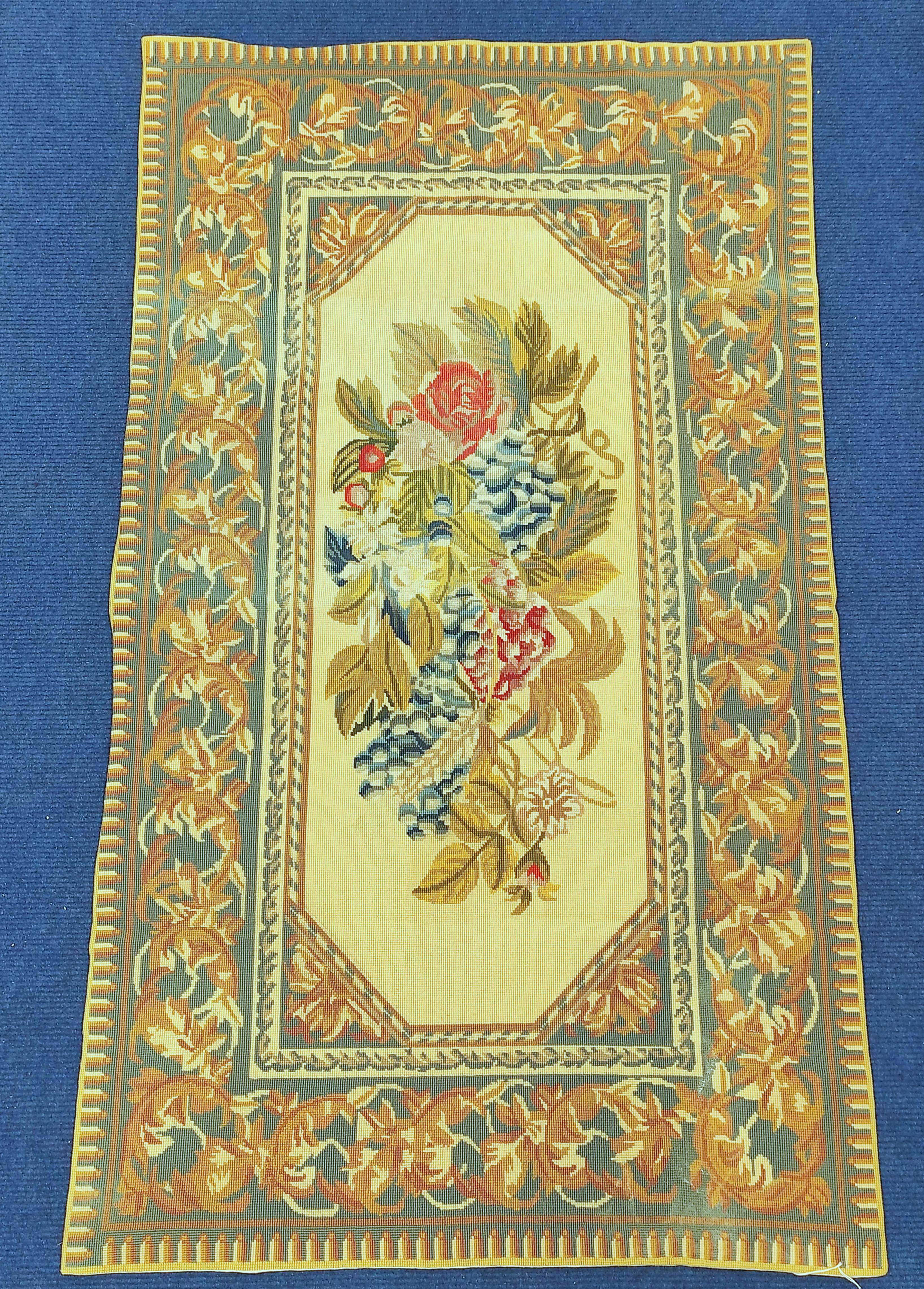 Gros point tapestry rug, the polychrome central floral panel with cream ground, surrounded by